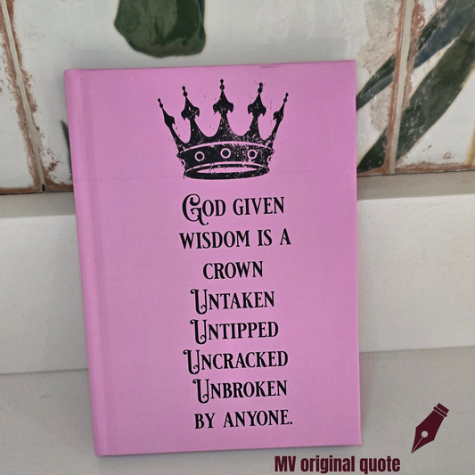 Pink faith journal featuring a crown and the quote “God Given Wisdom Is a Crown Untaken, Untipped, Uncracked, Unbroken by Anyone” on a tan background by motivated vision
