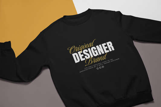 Black gildan 18000 crewneck sweatshirts with "Original Designer Brand "manufactured by text on it in white and gold letters. on multicolor background
