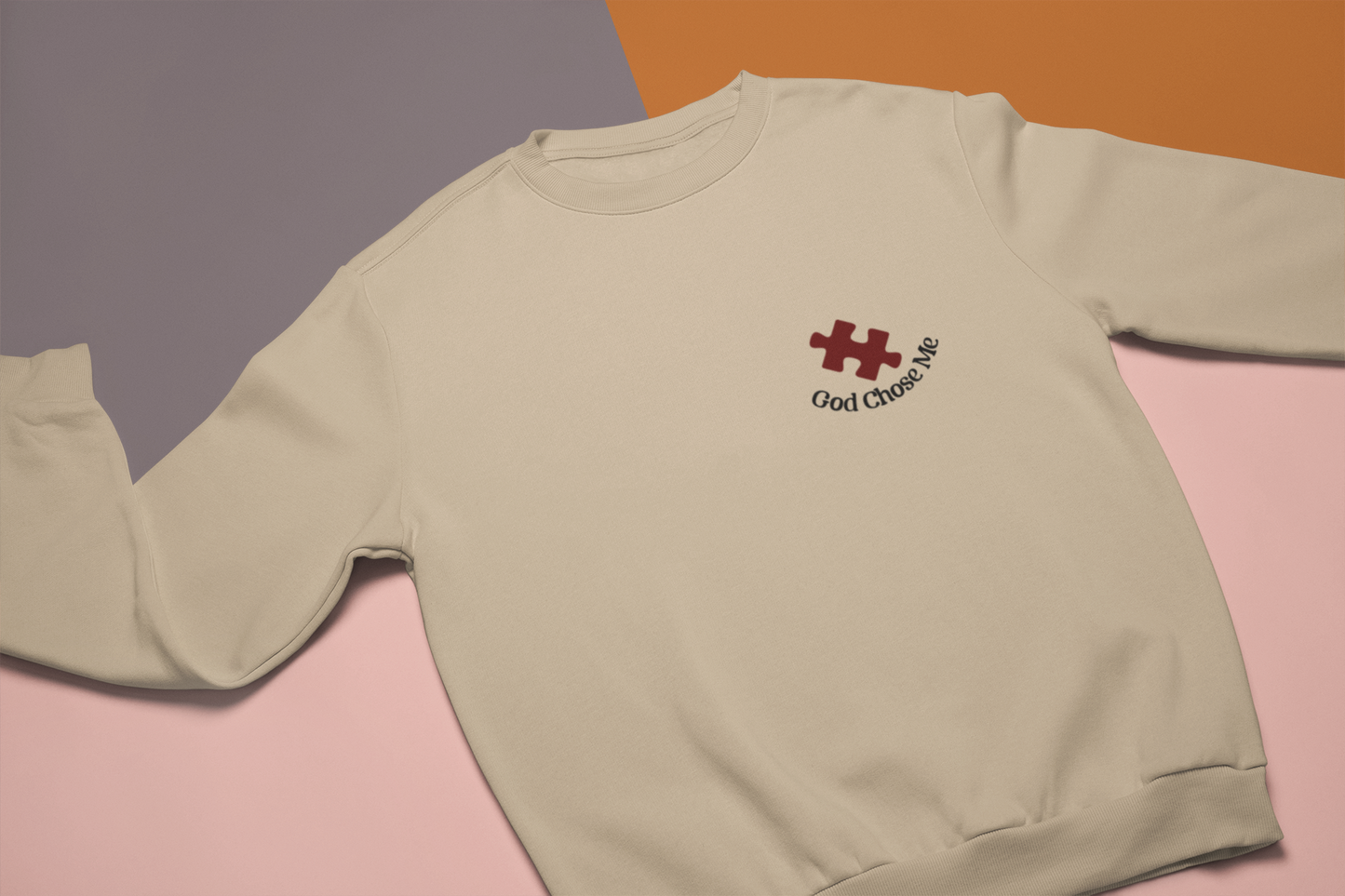 "God chose me" autism puzzle piece faith-based embroidery sweatshirt gildan 18000 sweatshirt sand. layed on multicolor background